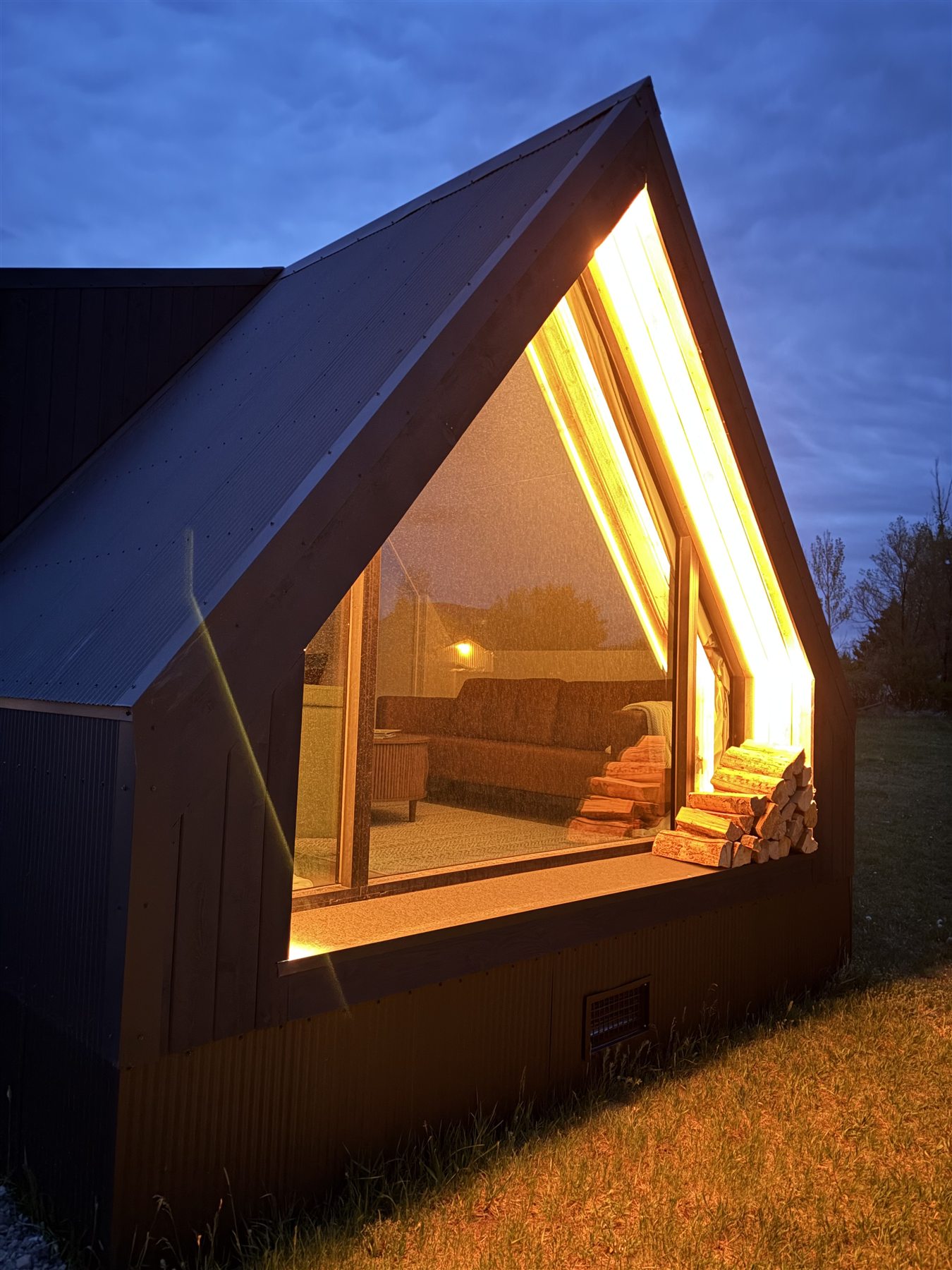 Glacier Mountain Getaway A-frame cabin glowing at evening near Bozeman